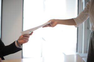 two people handing over document